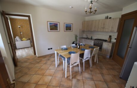 Tavolo da pranzo con sedie nella spaziosa cucina di La Cascina