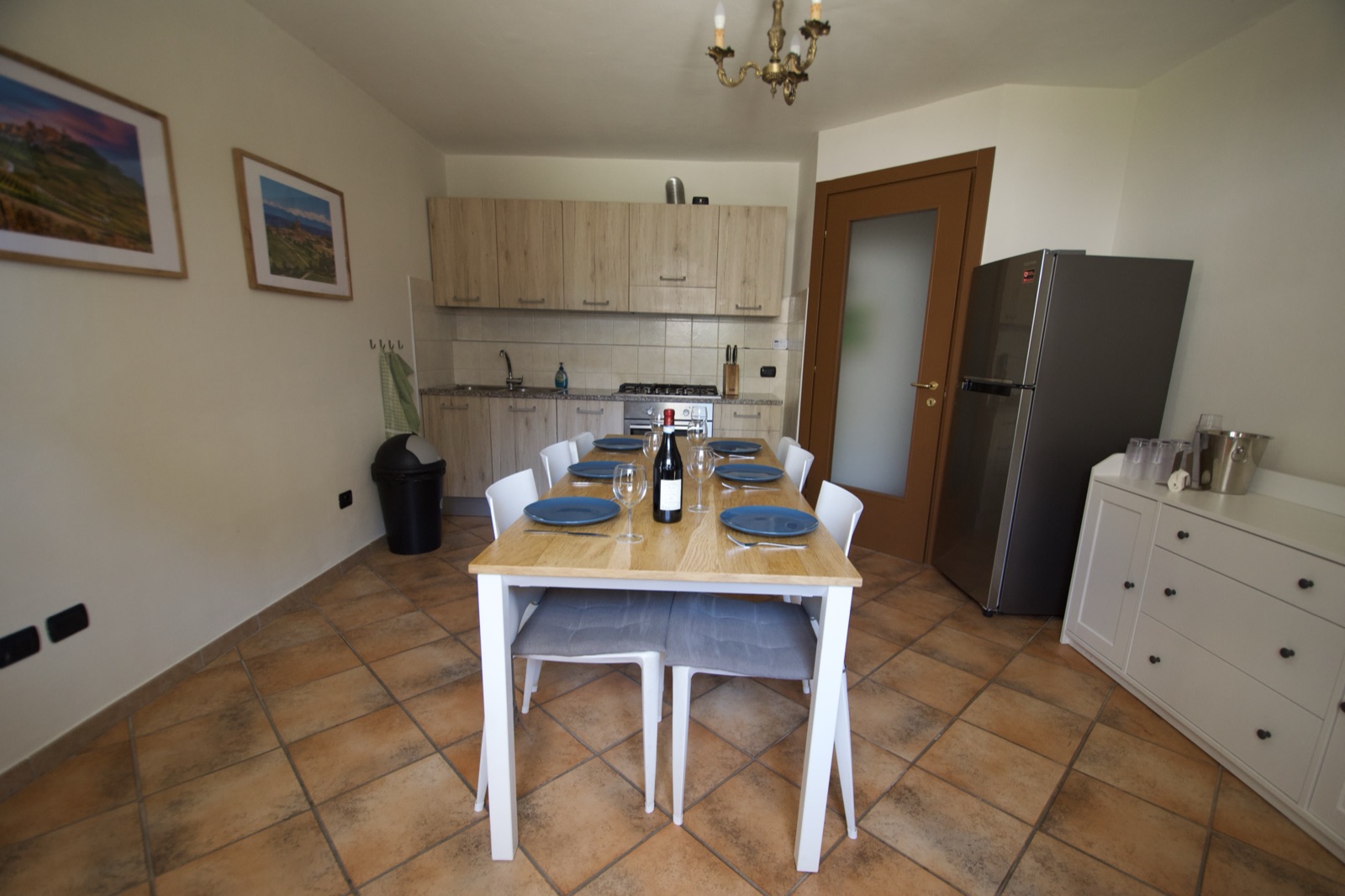 Keuken van La Cascina met eettafel, stoelen en keukenapparatuur