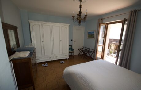 Camera da letto di La Cascina con armadio e portafinestra che dà sul balcone