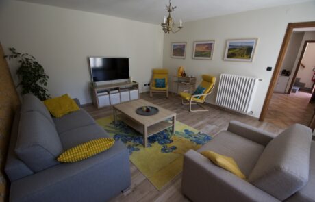 Soggiorno di La Cascina con televisione, tavolino, divano e poltrone