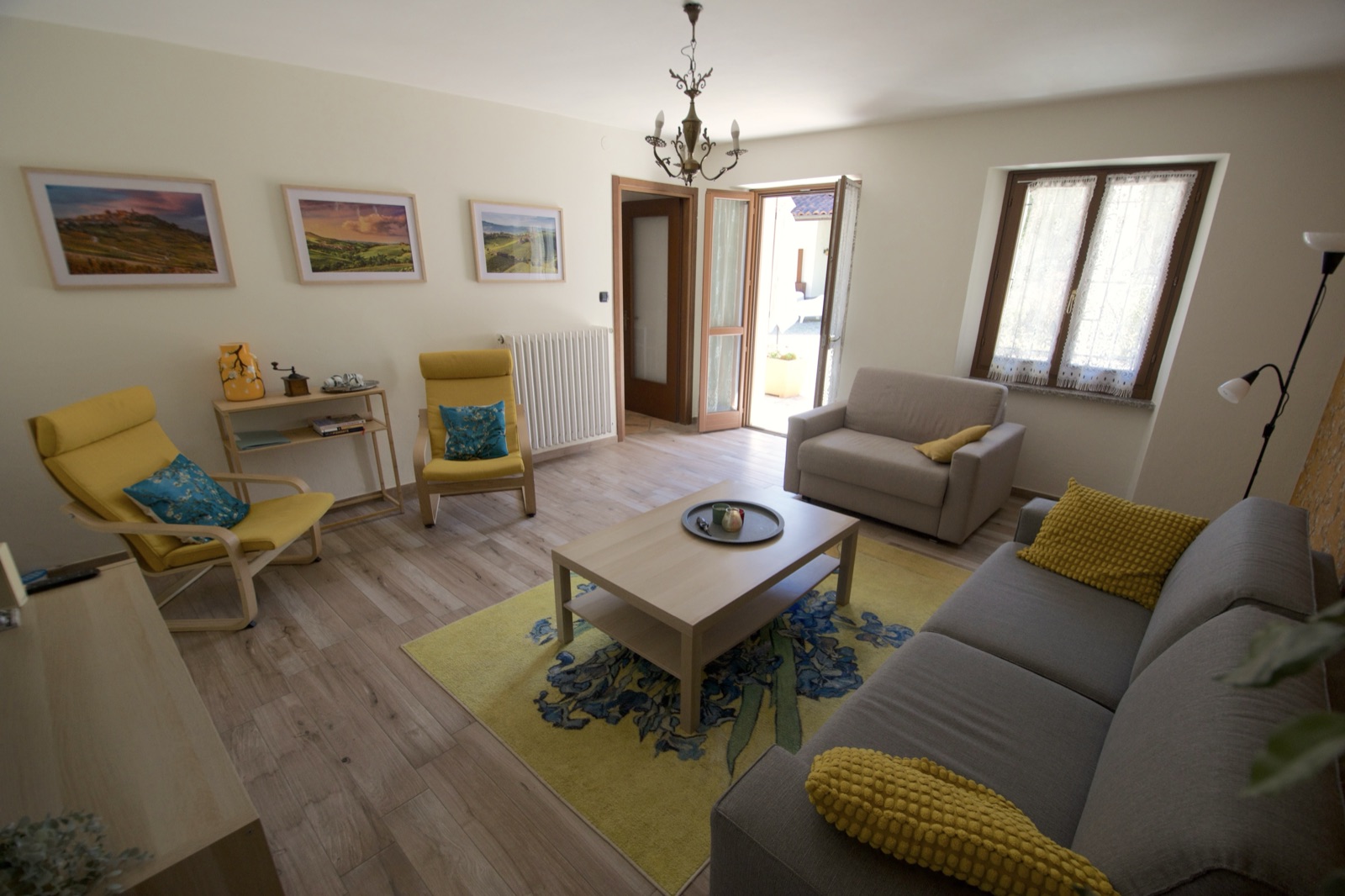 Overzicht van de woonkamer van La Cascina met zithoek en openslaande deur